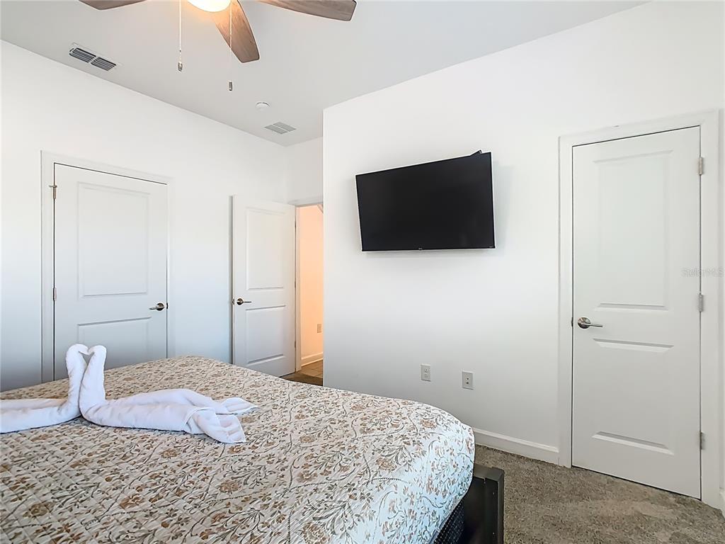 2957 Simile Street Kissimmee, FL 34746 - Photo 41 of 67 a bedroom with a bed and a flat screen tv