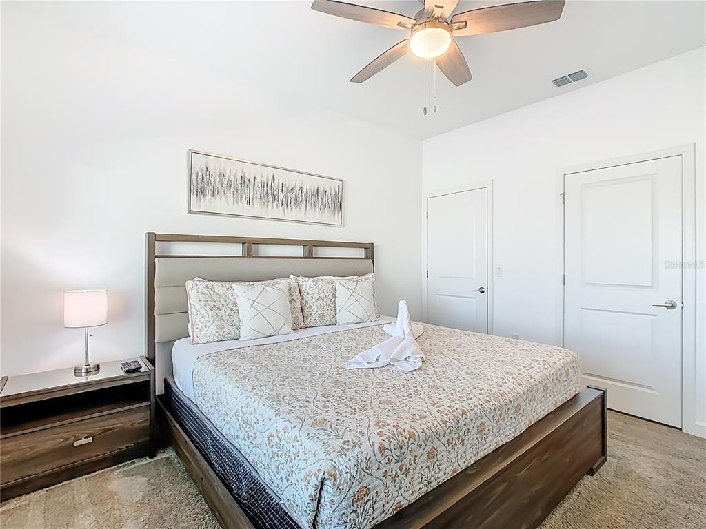 2957 Simile Street Kissimmee, FL 34746 - Photo 42 of 67 a bedroom with a bed and a lamp on a dresser