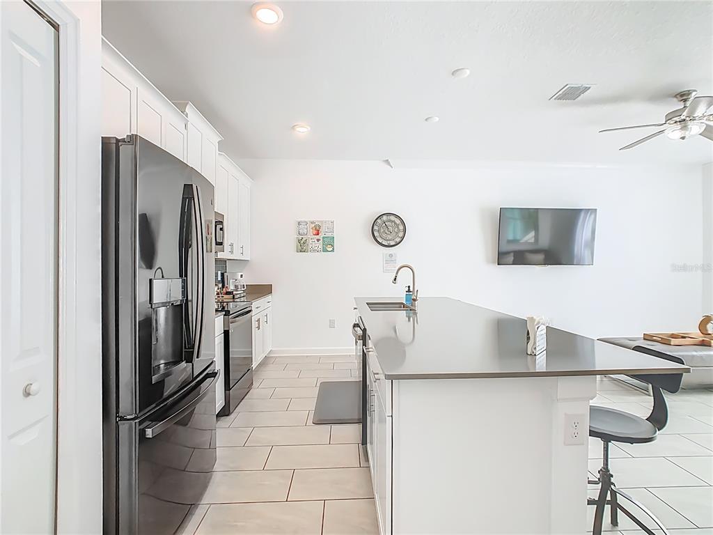 2957 Simile Street Kissimmee, FL 34746 - Photo 7 of 67 a kitchen with stainless steel appliances granite countertop a refrigerator and a sink