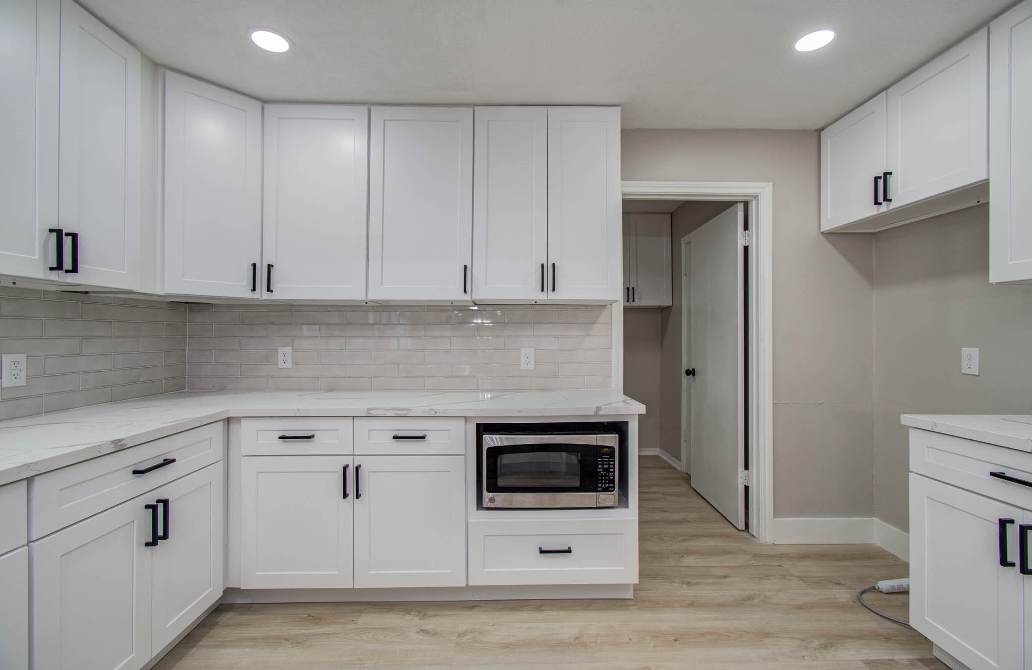 4735 Theall Road Houston, TX 77066 - Photo 19 of 36 a kitchen with white cabinets and white appliances