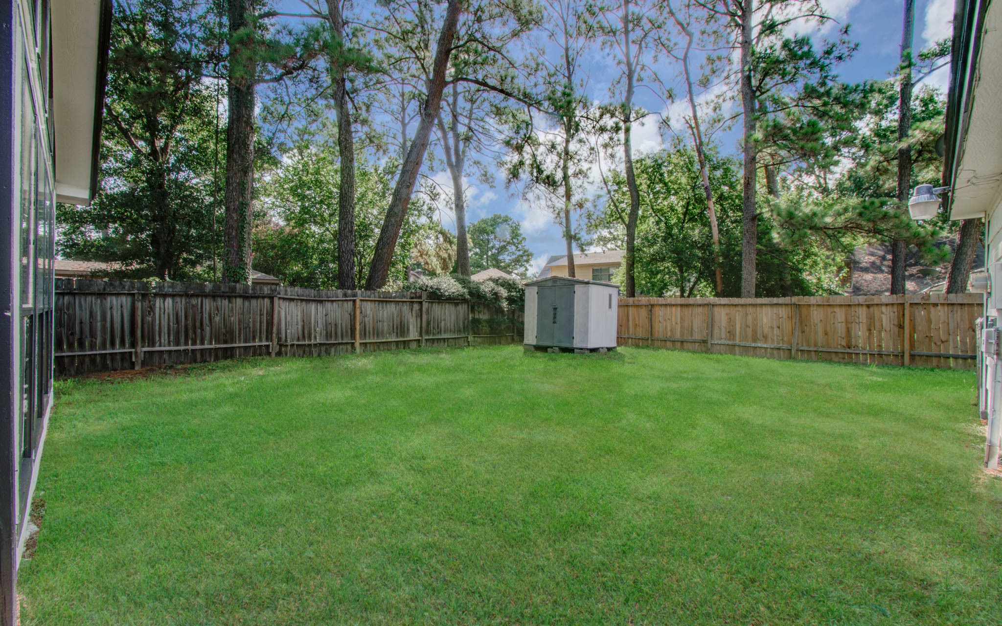 4735 Theall Road Houston, TX 77066 - Photo 34 of 36 a view of a backyard with large trees and wooden fence