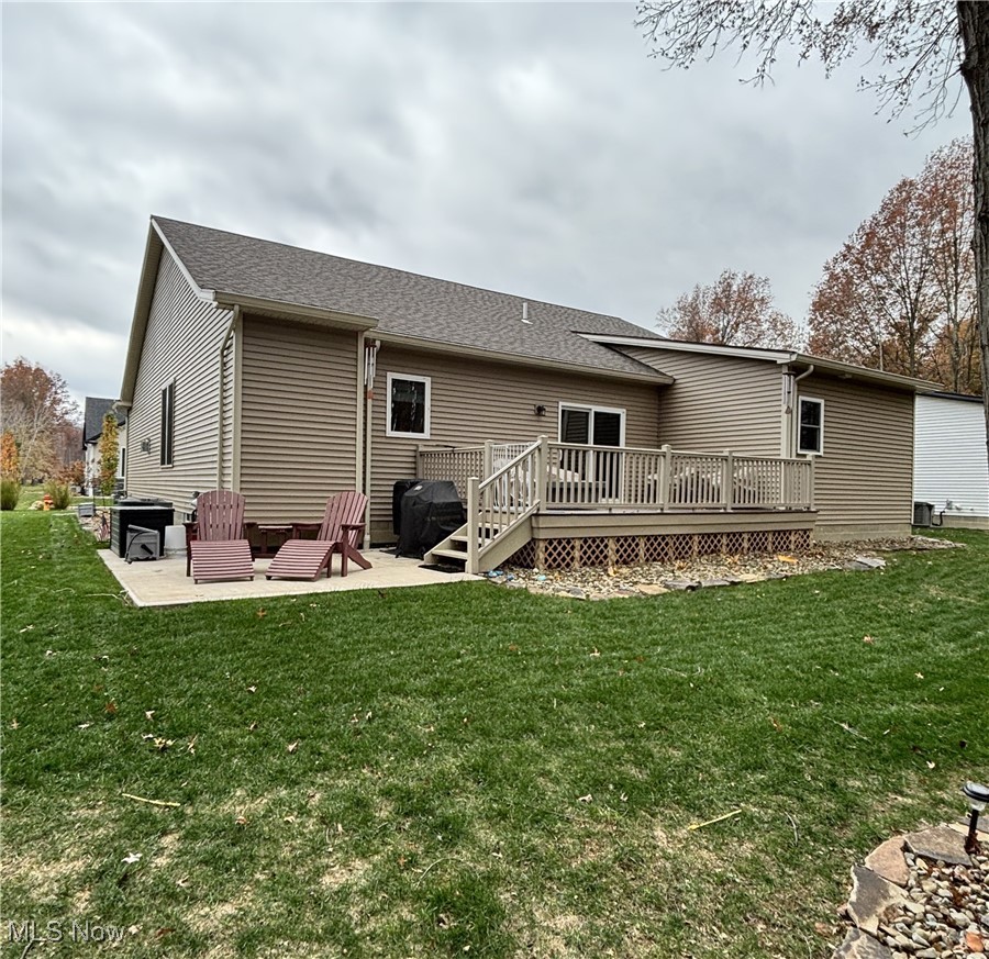 6580 Abbey Road North Canfield, OH 44406 - Photo 29 of 32 Rear view of house with a patio, a yard, a shingled roof, and a wooden deck