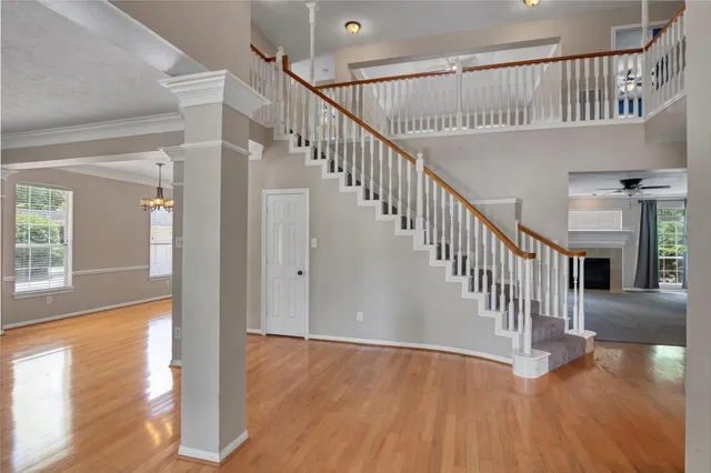 a view of a livingroom with a fireplace a ceiling fan and windows