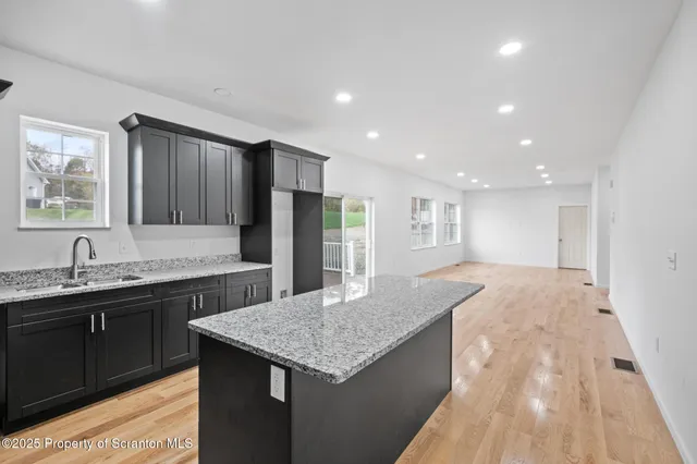 a kitchen with granite countertop kitchen island a sink appliances and a counter space
