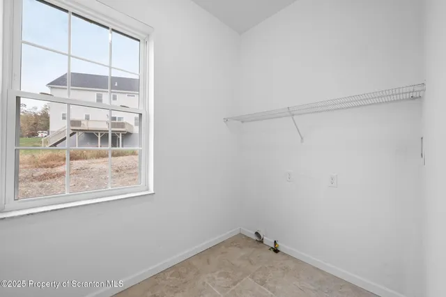 a view of an empty room with a window and a ceiling fan