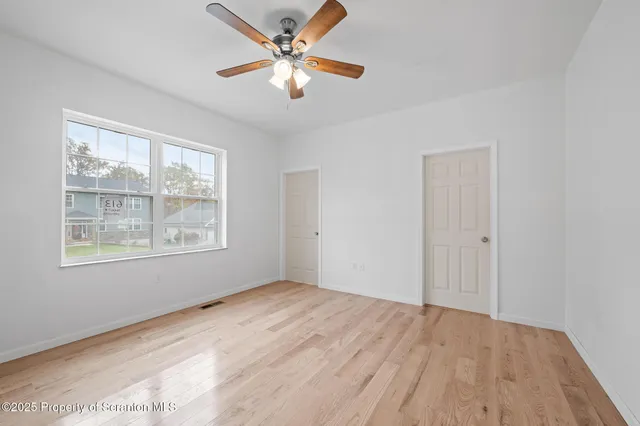 a view of a white house next to yard