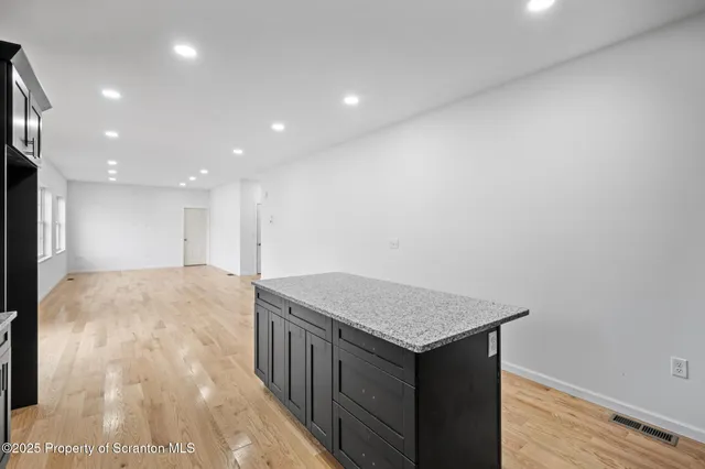 a large kitchen with kitchen island a sink stainless steel appliances and cabinets