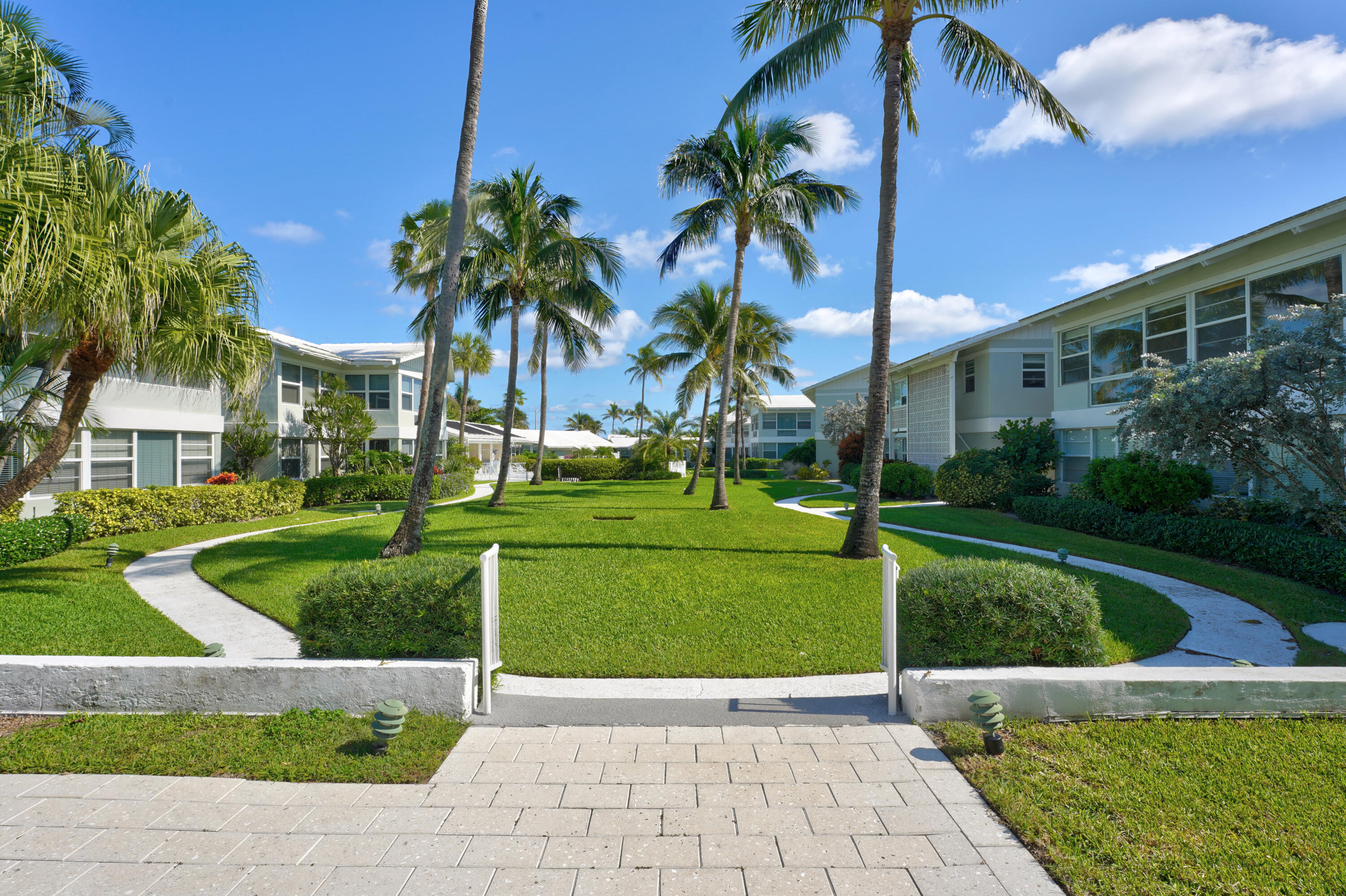 320 South Ocean Boulevard, Unit UK Delray Beach, FL 33483 - Photo 2 of 27 a view of a white house with a yard and potted plants