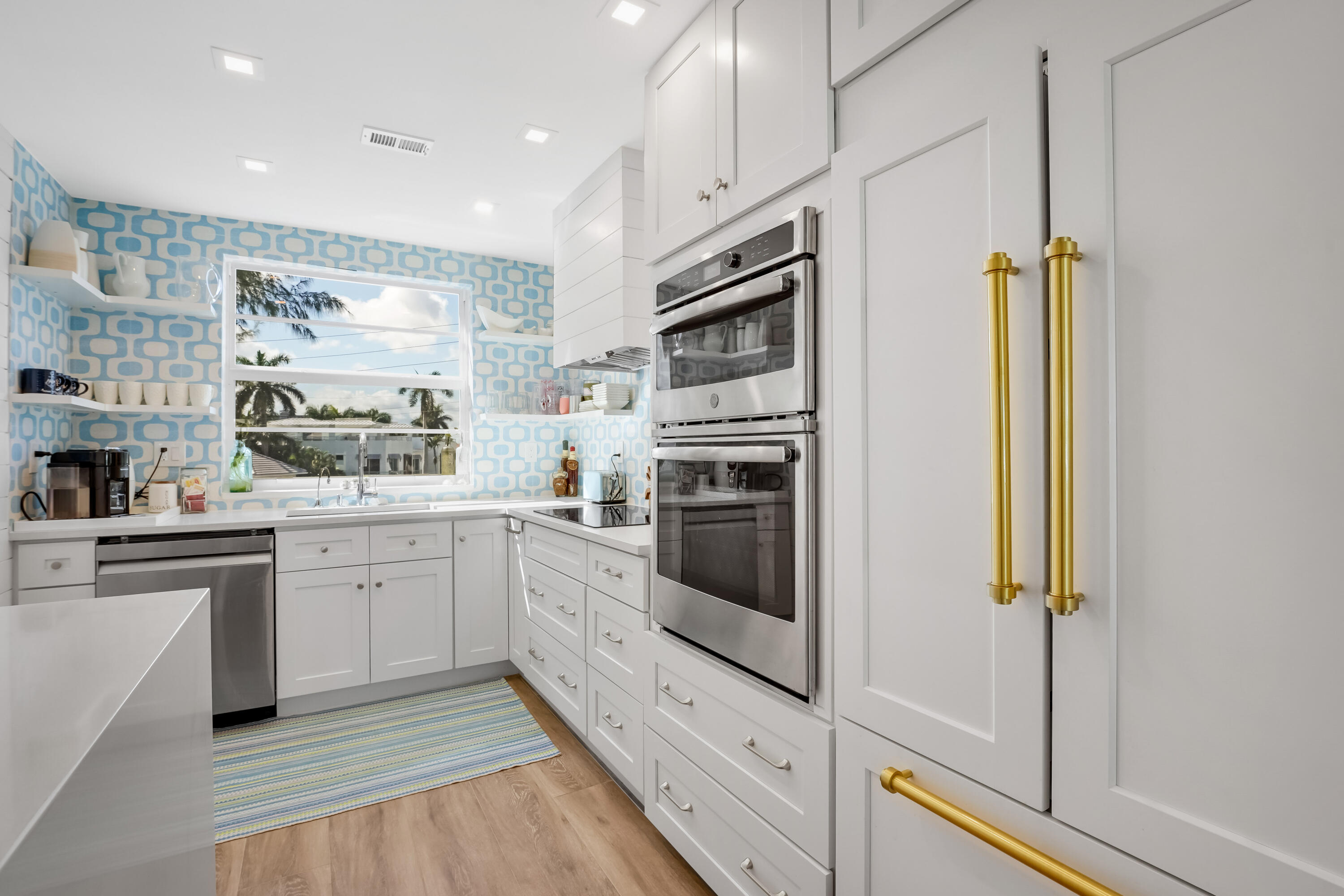 320 South Ocean Boulevard, Unit UK Delray Beach, FL 33483 - Photo 9 of 27 a kitchen with white cabinets and white appliances