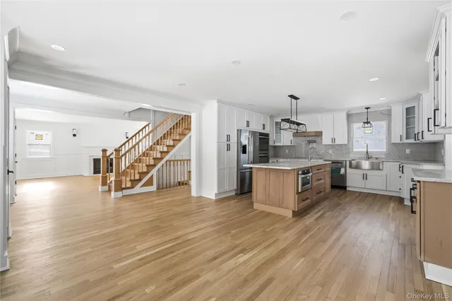 a large kitchen with stainless steel appliances granite countertop a large center island and a wooden floors