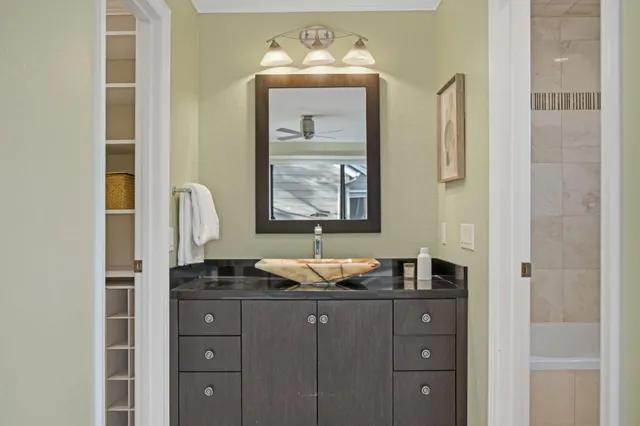 a bathroom with a granite countertop toilet sink and mirror