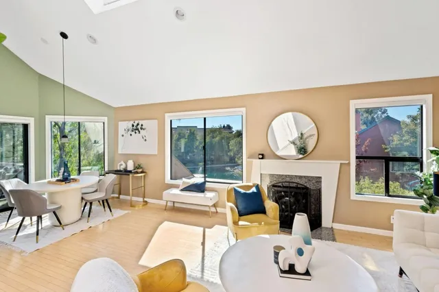a living room with furniture a fireplace and a large window
