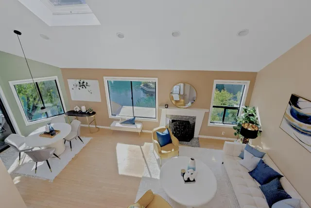 a living room with furniture a large window and a fireplace