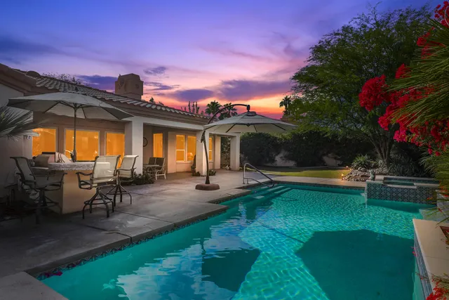a view of a house with swimming pool and sitting area
