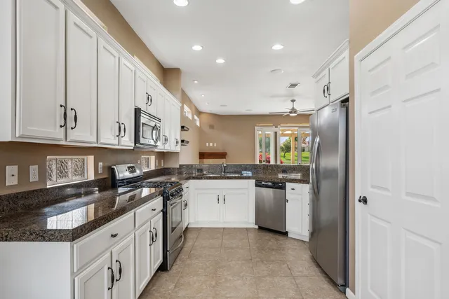 a kitchen with stainless steel appliances granite countertop a sink and cabinets