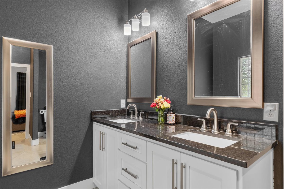 145 Cardinal Loop Paige, TX 78659 - Photo 23 of 40 Double vanity featuring granite counters and two mirrors creates a streamlined, efficient morning routine.