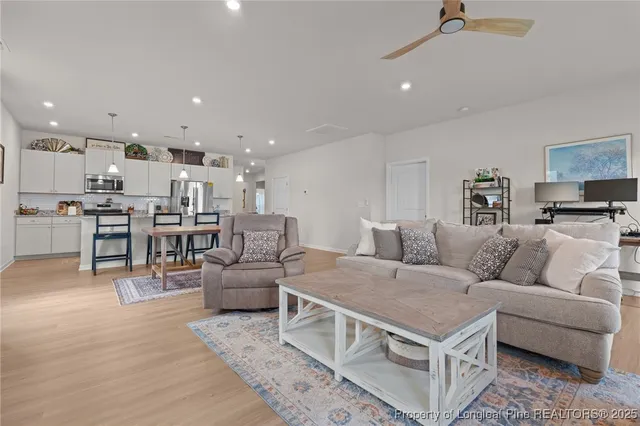 a living room with furniture and a view of kitchen