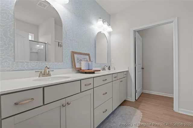 a bathroom with double sink and a mirror