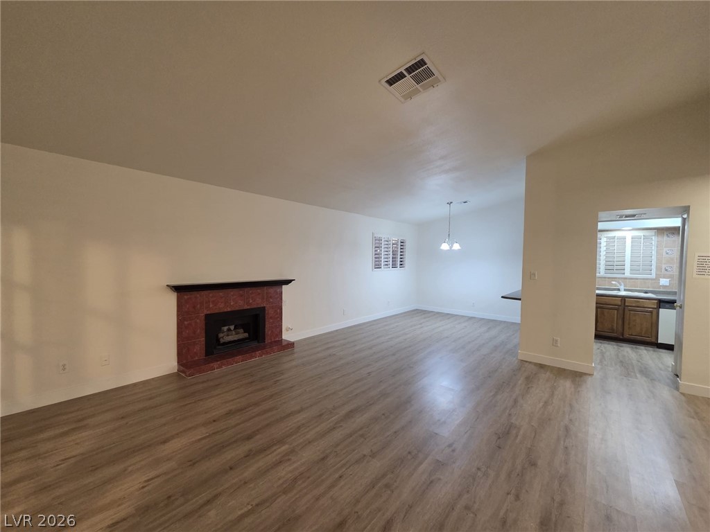 3317 Racquet Street Las Vegas, NV 89121 - Photo 2 of 23 This inviting space features a tiled fireplace, wood flooring, and a seamlessly connected kitchen area.