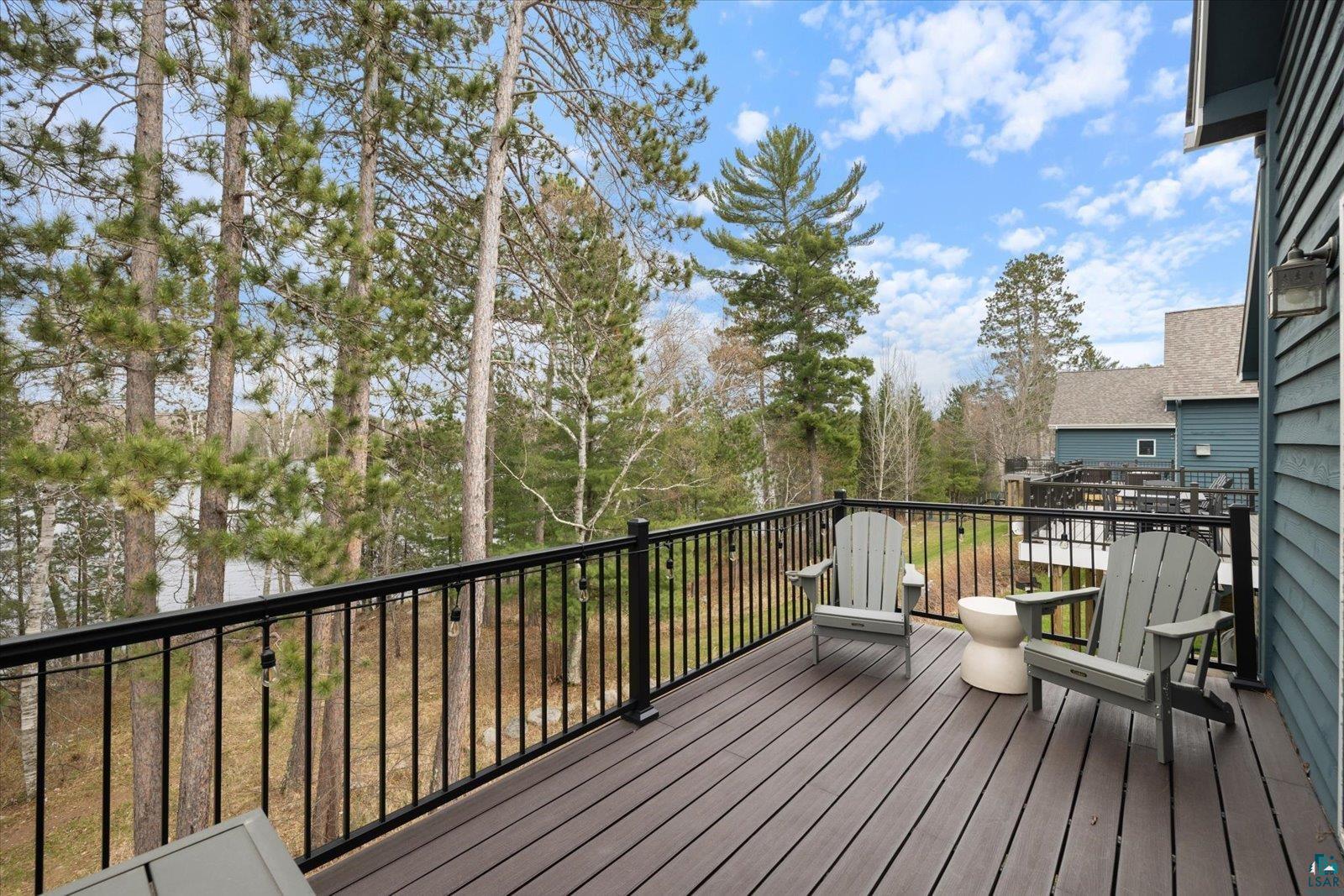 6266 Giants Ridge Road Biwabik, MN 55705 - Photo 7 of 37 Exterior deck featuring composite decking, black metal railings, and a blue siding facade