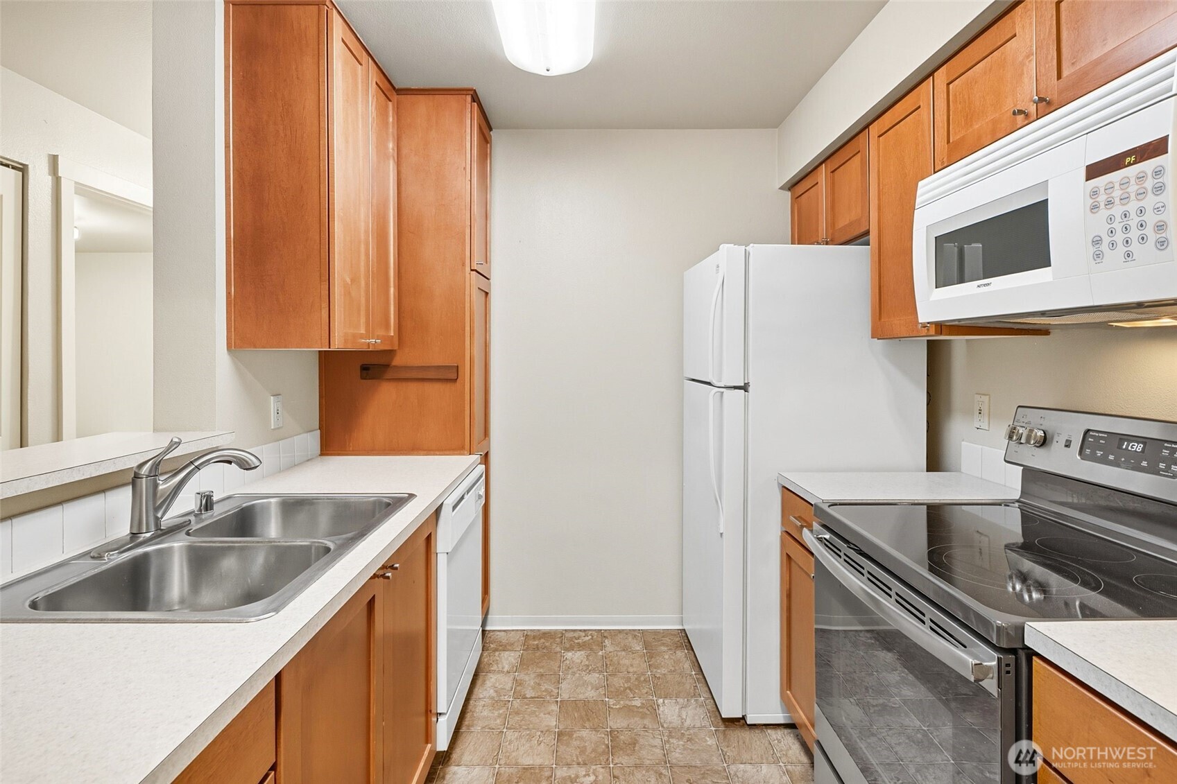 12303 Harbour Pointe Boulevard, Unit Z207 Mukilteo, WA 98275 - Photo 11 of 35 a kitchen with stainless steel appliances granite countertop a refrigerator and a sink