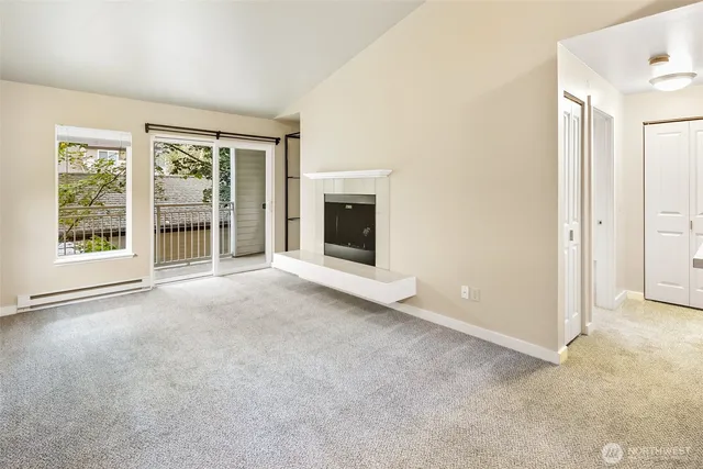 a view of an empty room with a fireplace and a window