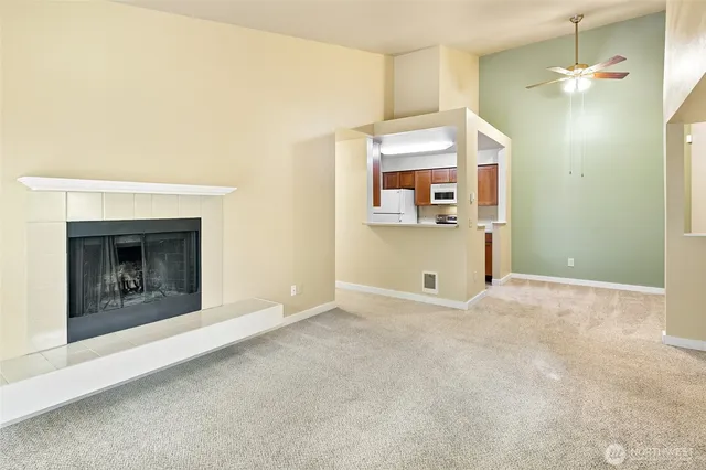 an empty room with a fireplace and fan