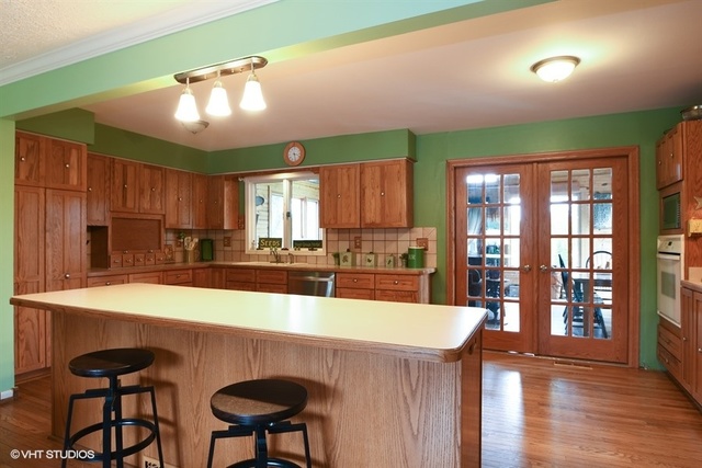 25125 South Rondorey Road Elwood, IL 60421 - Photo 8 of 45 a kitchen with stainless steel appliances wooden floor dining table and chairs