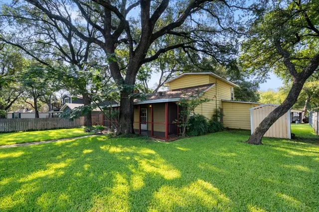a view of a yard with a house and a large tree