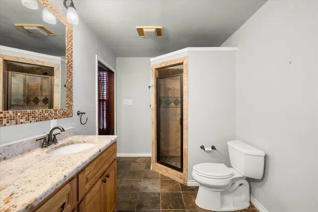 a bathroom with a granite countertop sink toilet and shower