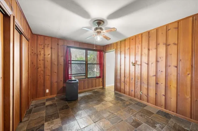 a view of a hallway with windows and chandelier fan