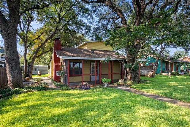a view of a house with a yard and tree