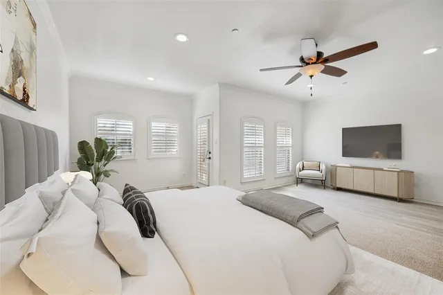 a spacious bedroom with a bed a couch and a flat screen tv