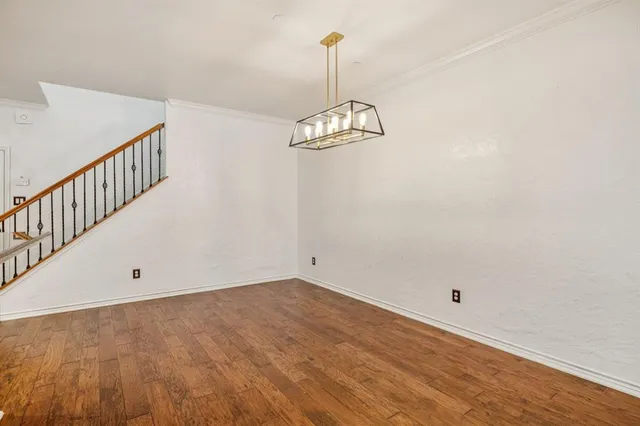 a view of a room with wooden floor and white walls