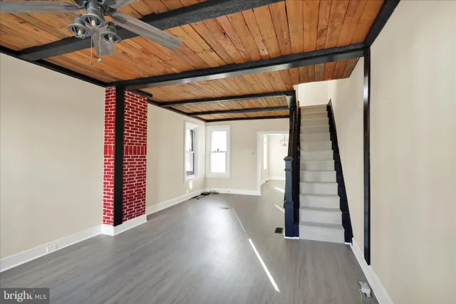 a view of a hallway with wooden floor and stairs
