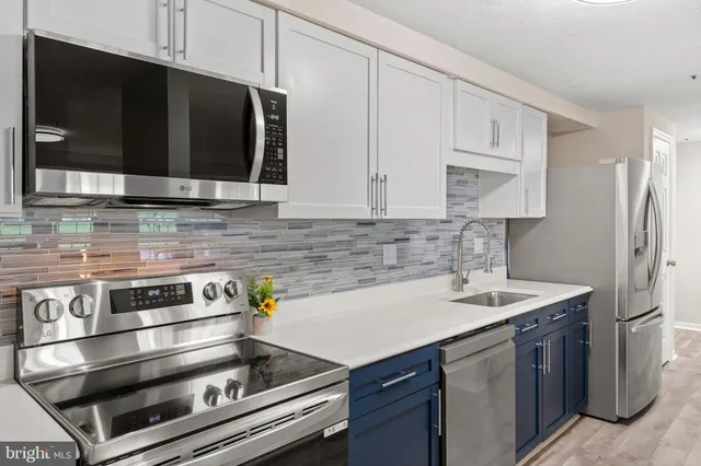 a kitchen with stainless steel appliances granite countertop a sink stove and microwave