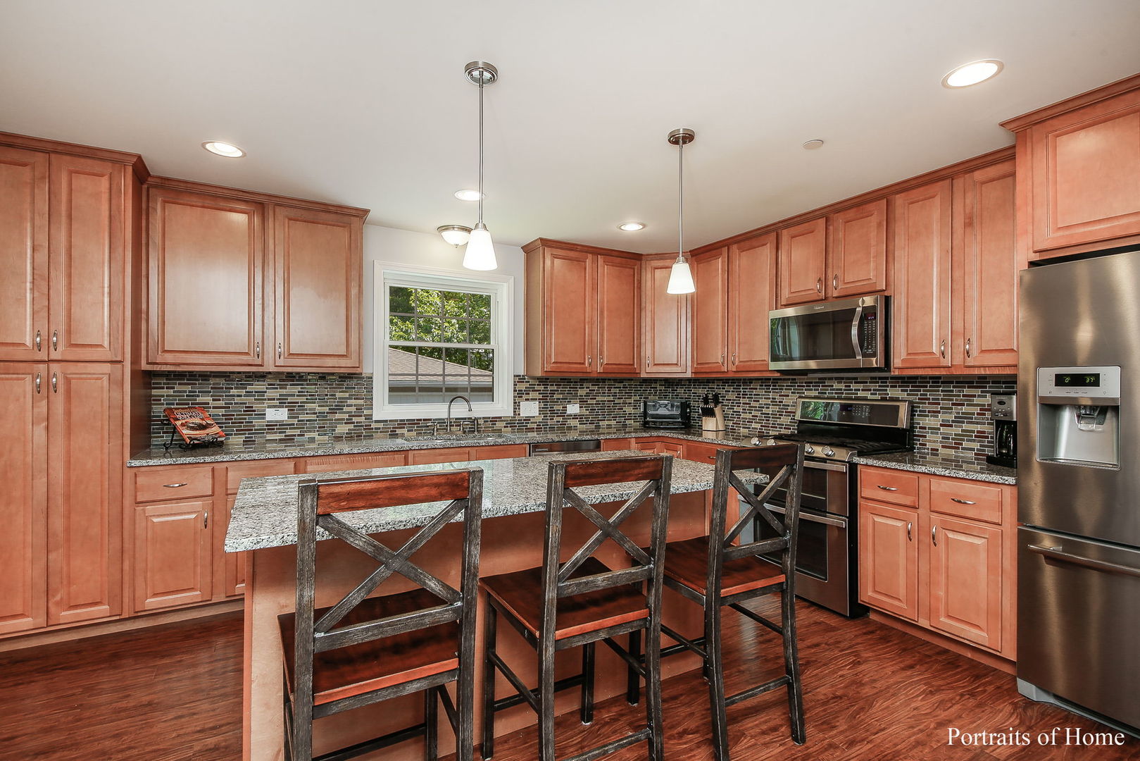 231 Highland Road Willowbrook, IL 60527 - Photo 7 of 38 a kitchen with stainless steel appliances granite countertop a stove top oven a sink dishwasher a dining table and chairs with wooden floor