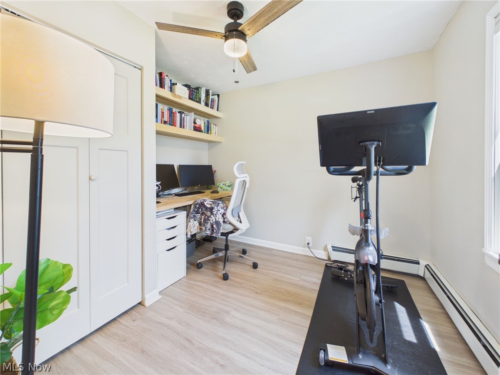 3490 County Line Road Madison, OH 44057 - Photo 35 of 42 Versatile room featuring wood-finish flooring, a built-in desk with shelving, a ceiling fan with light, and bi-fold closet doors