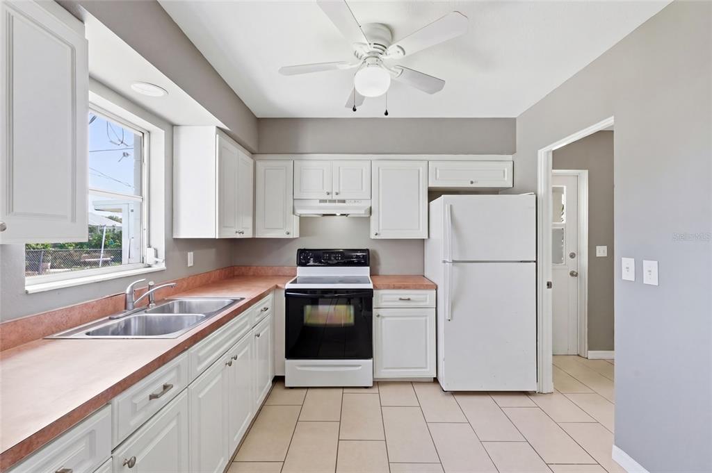 363 Glen Oak Road Venice, FL 34293 - Photo 19 of 53 a kitchen with a refrigerator sink and white cabinets