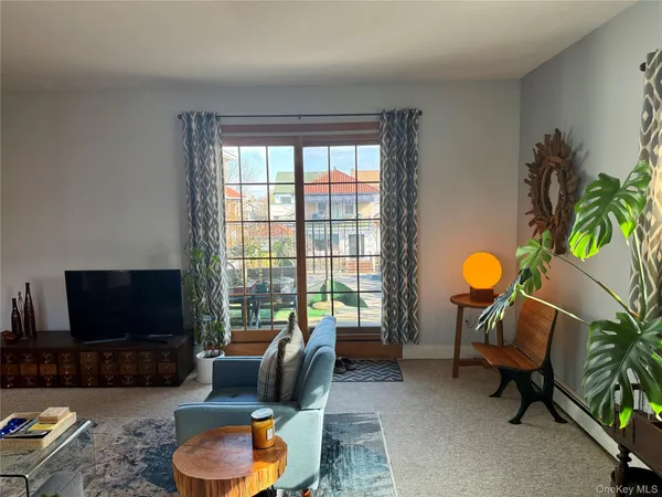 a living room with furniture a flat screen tv and a large window