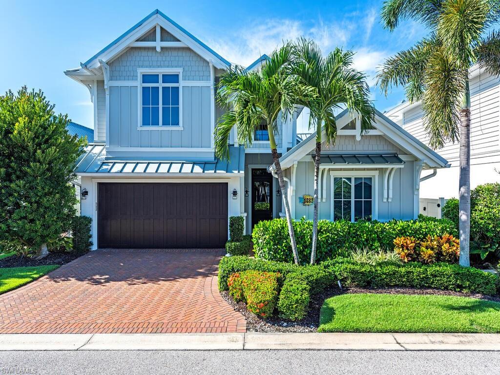 a front view of a house with a yard and potted plants