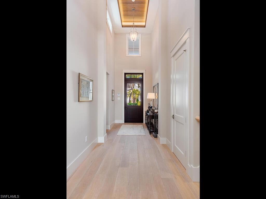1482 2nd Avenue South Naples, FL 34102 - Photo 17 of 25 a view of a hallway with wooden floor and a living room