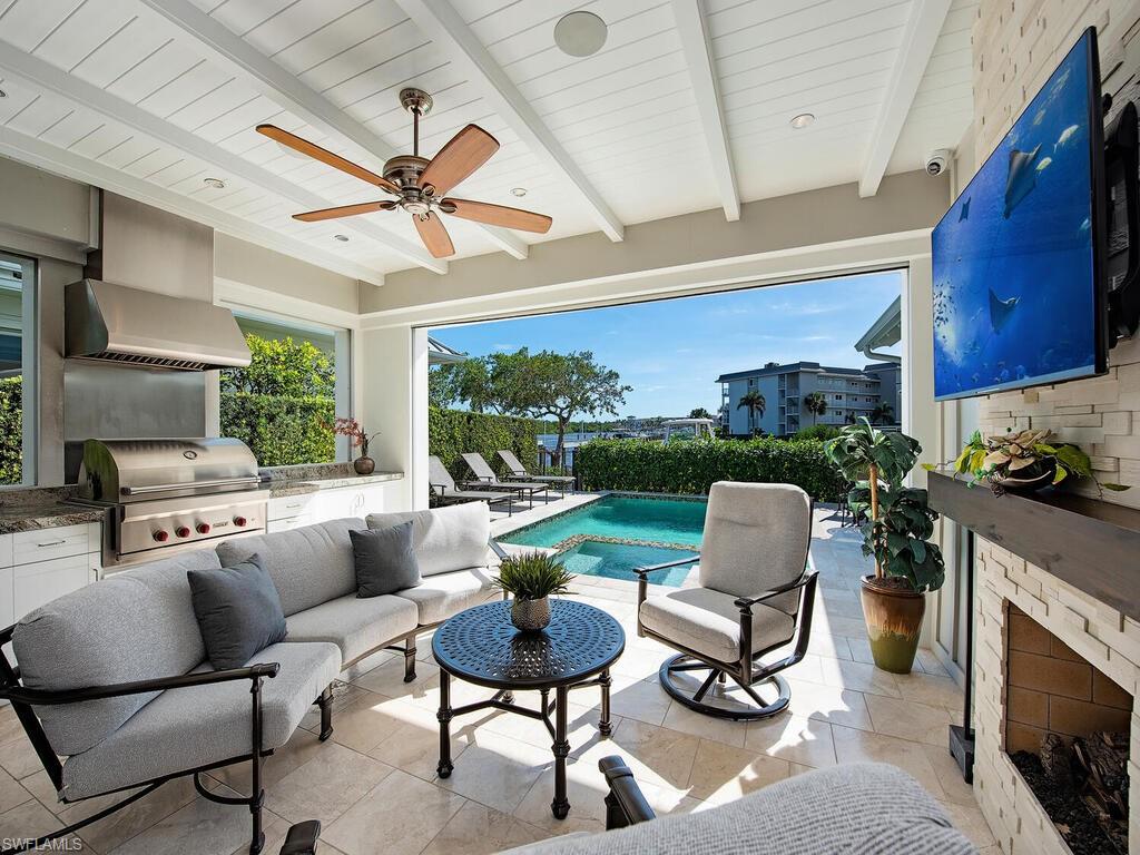 1482 2nd Avenue South Naples, FL 34102 - Photo 8 of 25 a living room with patio furniture and a fireplace