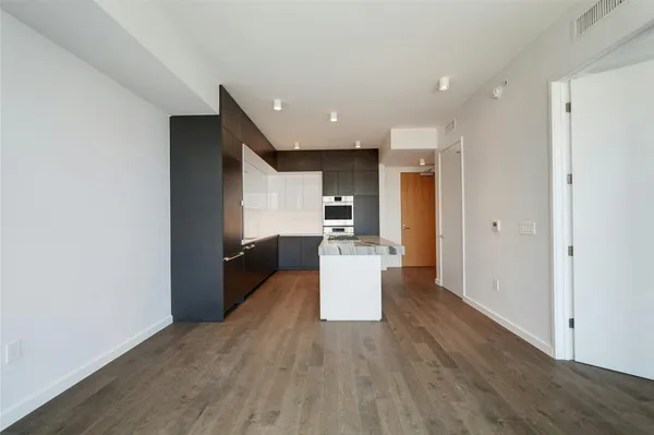 a view of a kitchen with cabinets stainless steel appliances and wooden floor
