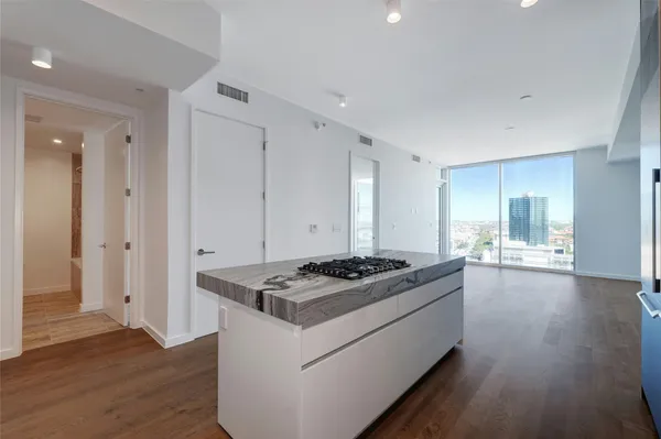 a kitchen with granite countertop stove a sink and wooden floor