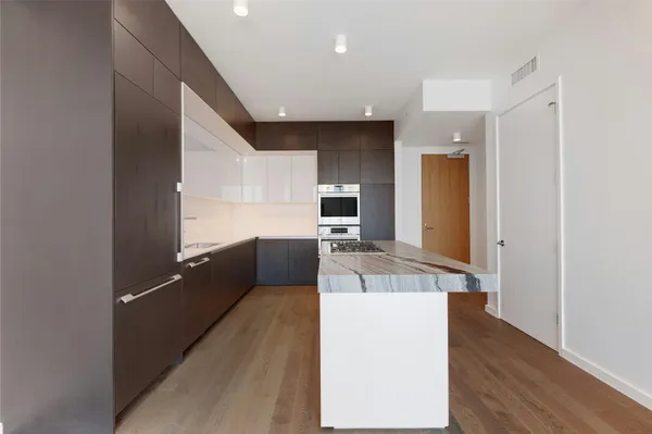 a kitchen with granite countertop a refrigerator and a stove top oven