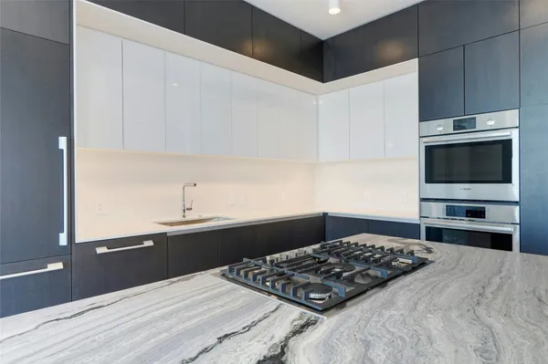 a kitchen with stainless steel appliances a stove a sink and a microwave