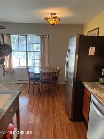 a dining room with furniture a floor to ceiling window and wooden floor