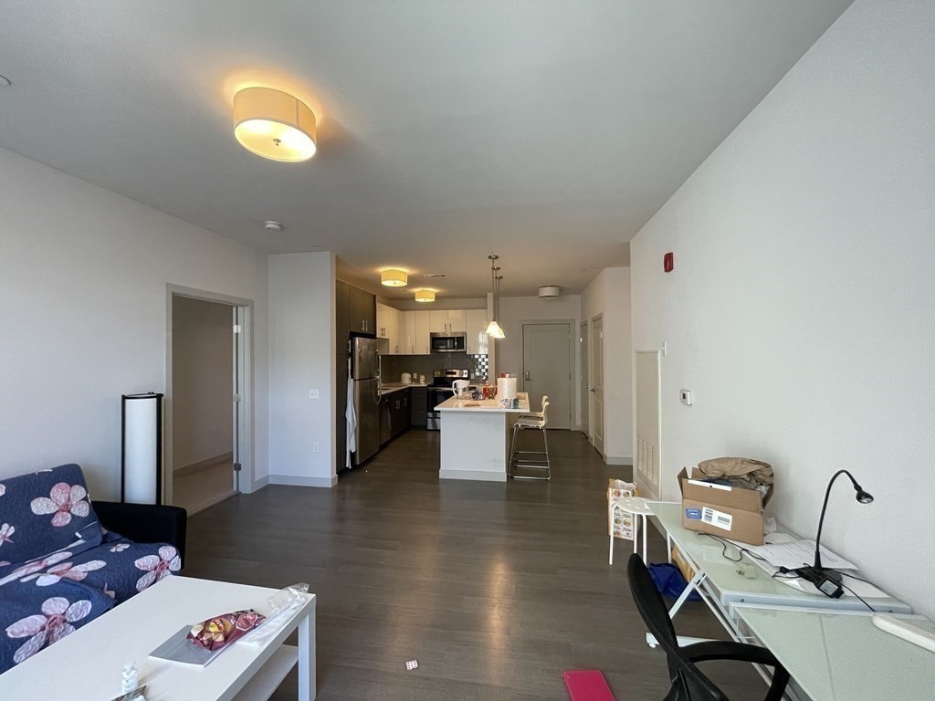 99 Tremont Street, Unit 313 Boston, MA 02135 - Photo 5 of 13 a living room with furniture and a table