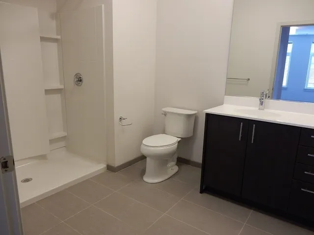 a bathroom with a sink a toilet and shower